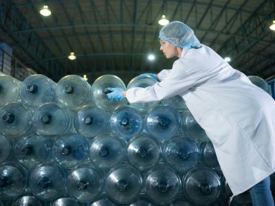 Portrait of a scientist in the drinking water factory using a ladder, looking at the water tanks Portrait of a scientist in the drinking water factory using a ladder, looking at the water tanks